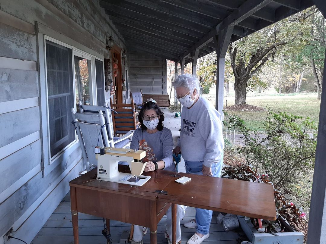 A woman and her mother-in-law study a sewing machine to find the problem.